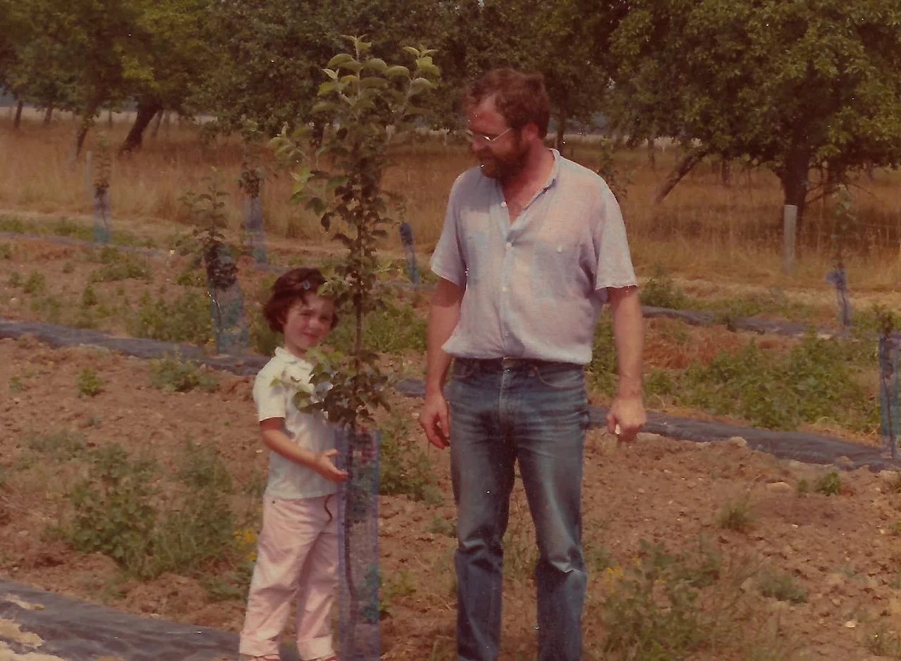 Jean-René Pitrou y un niño frente a un manzano joven recién plantado, manzanal del Domaine des Cinq Autels, 1984